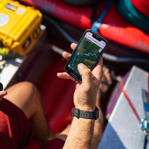 Phone in hand displaying PaddleWays map while on a raft